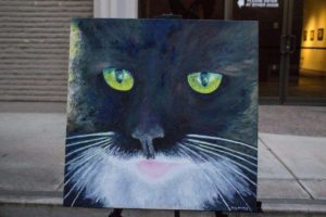 Greg Stanley created a poem and painting inspired by the green color of his cat's eyes. He read the poem and showed the painting at the Visions of Words event. 